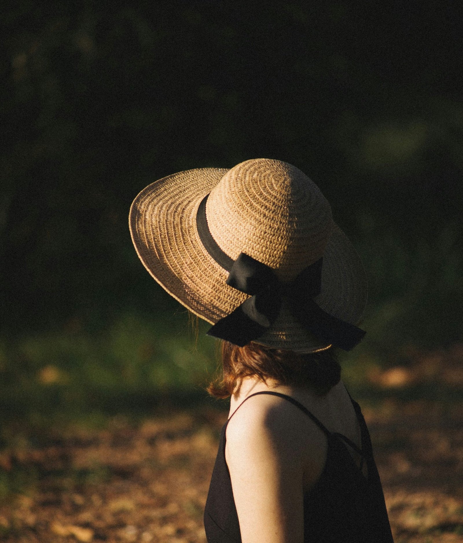 woman in black tank top wearing brown sun hat